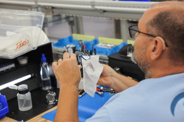 IcareLabs technician performing final inspection and cleaning of prescription eyewear