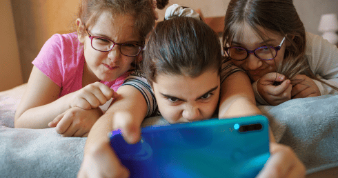 kids on their phone with harmful blue light protective glasses