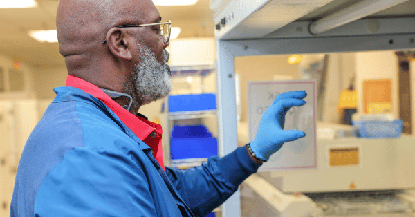 IcareLabs optical lab technician inspecting an ophthalmic lens during production